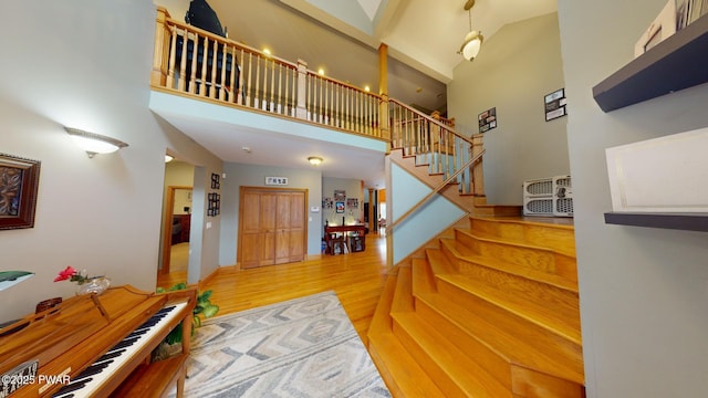 stairs with a high ceiling and hardwood / wood-style flooring