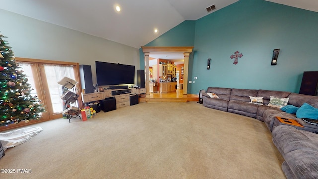 living room with high vaulted ceiling, decorative columns, and light carpet