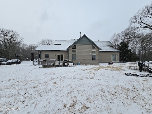 view of snow covered back of property