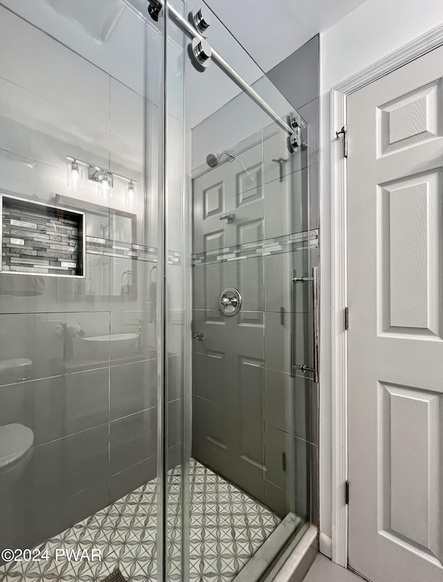 bathroom featuring a shower with door