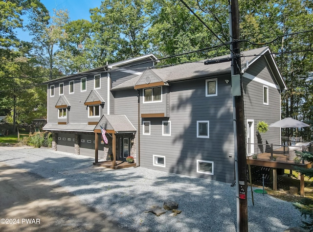 view of front facade with a wooden deck and a garage