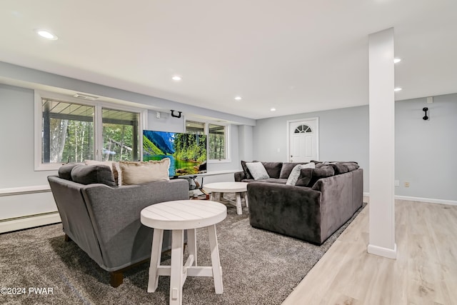 living room with light wood-type flooring and a baseboard heating unit