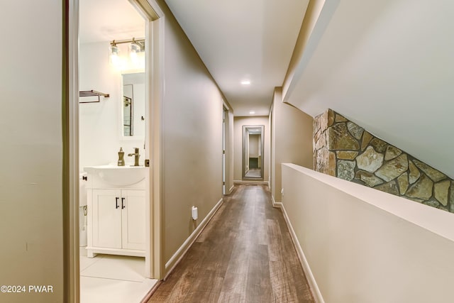 corridor with hardwood / wood-style flooring and sink