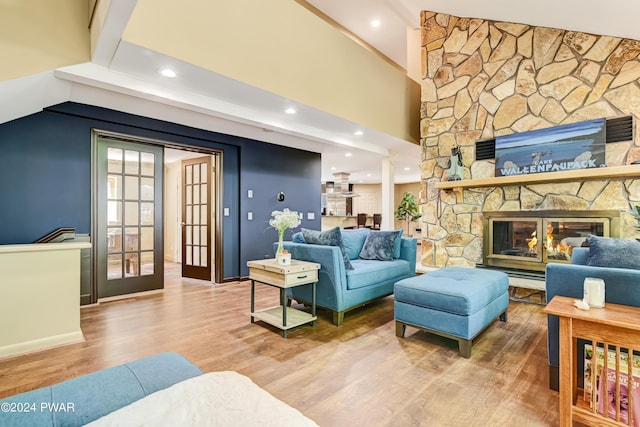 living room with a fireplace, wood-type flooring, and vaulted ceiling with beams