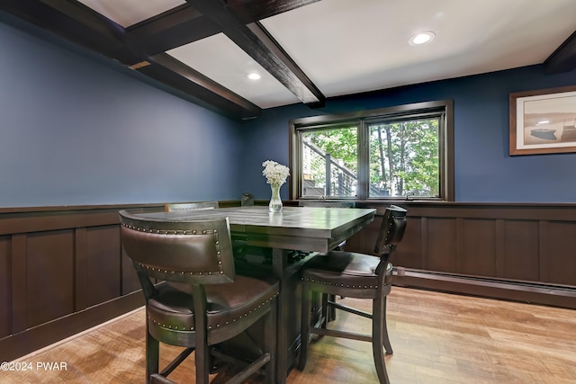 dining room featuring beamed ceiling, a baseboard radiator, and light hardwood / wood-style floors