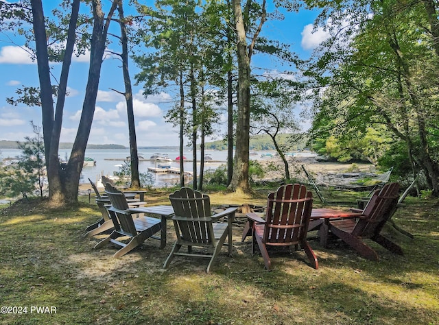 view of yard featuring a water view and an outdoor fire pit