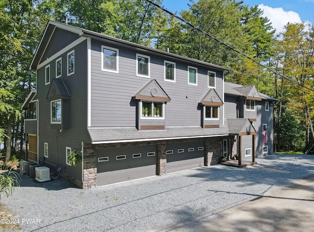 view of front facade with cooling unit and a garage