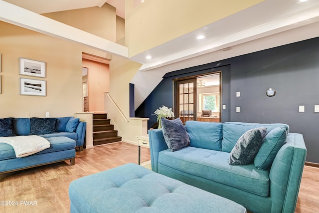 living room with light hardwood / wood-style floors and high vaulted ceiling