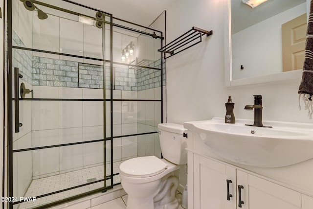 bathroom featuring tile patterned floors, vanity, toilet, and a shower with door