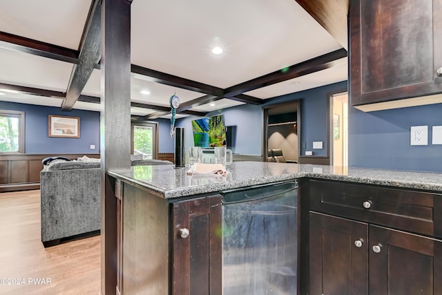 kitchen with light stone countertops, stainless steel dishwasher, a healthy amount of sunlight, beam ceiling, and light hardwood / wood-style flooring