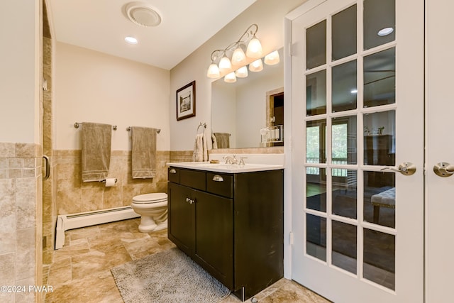 bathroom with baseboard heating, vanity, tile walls, and toilet