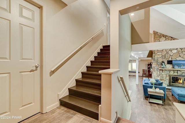 stairway featuring a fireplace and hardwood / wood-style flooring