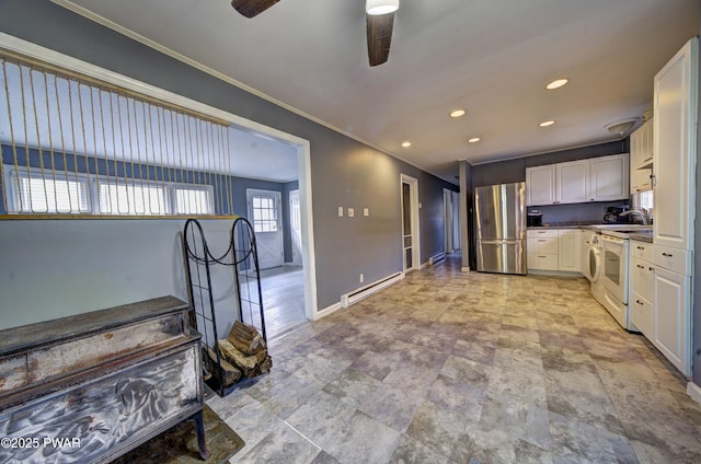 kitchen with freestanding refrigerator, baseboards, a baseboard heating unit, ceiling fan, and white cabinetry