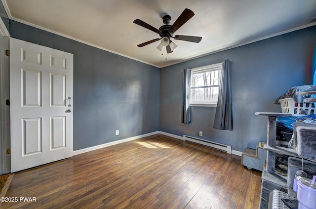 spare room featuring a baseboard radiator, baseboards, wood-type flooring, ceiling fan, and crown molding