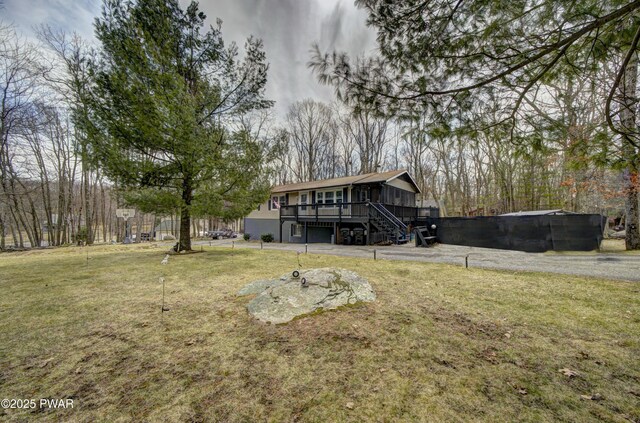 back of property featuring a lawn, stairway, and a wooden deck