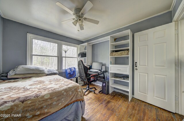 bedroom featuring ceiling fan, ornamental molding, and wood-type flooring