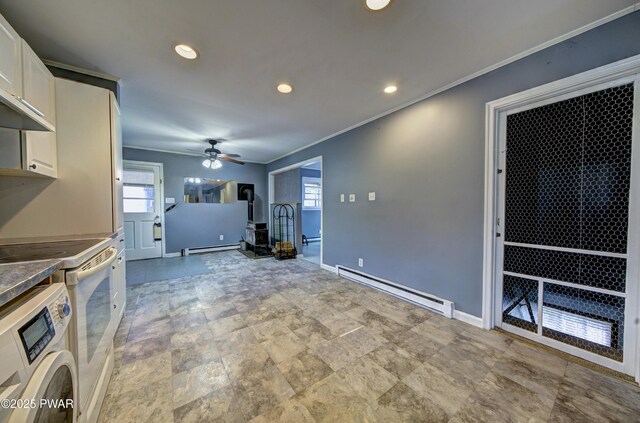 unfurnished living room with a baseboard radiator, baseboards, and washer / clothes dryer