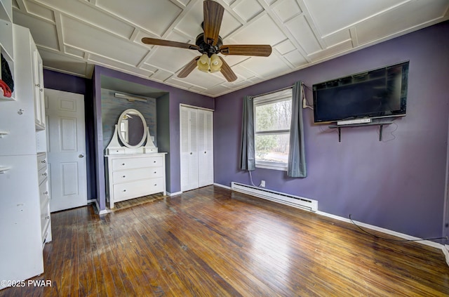unfurnished bedroom featuring ceiling fan, baseboards, a baseboard heating unit, and hardwood / wood-style flooring