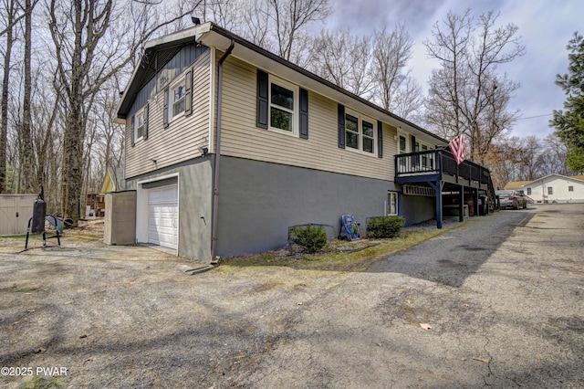 view of side of home with a wooden deck and a garage