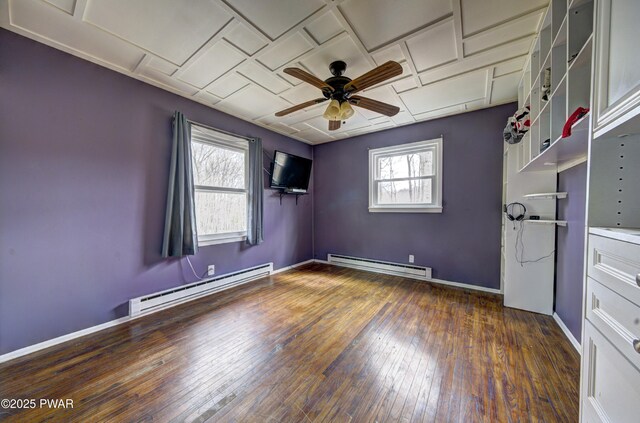 empty room with a baseboard radiator, wood-type flooring, baseboards, and ceiling fan