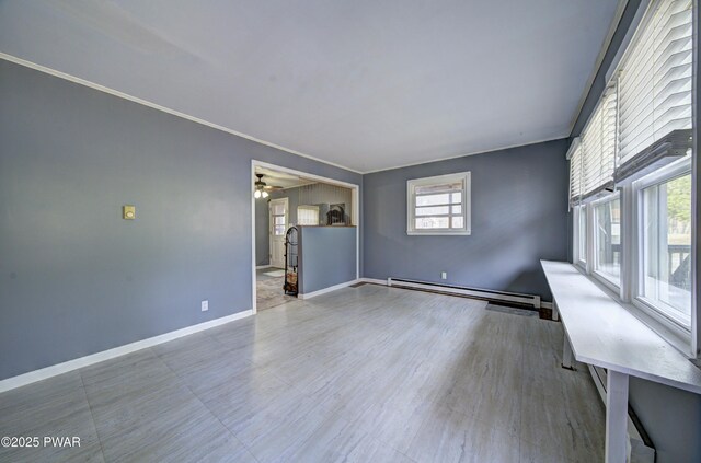 unfurnished living room featuring a ceiling fan, baseboards, baseboard heating, and ornamental molding