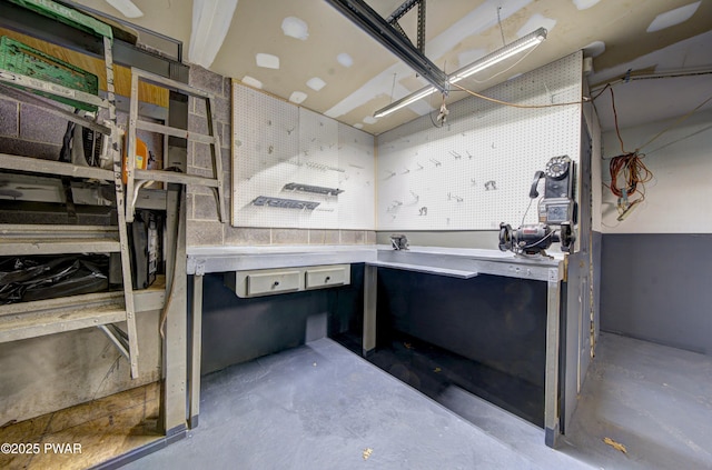 miscellaneous room with a workshop area and unfinished concrete floors