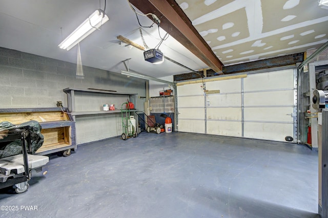garage featuring concrete block wall and a garage door opener
