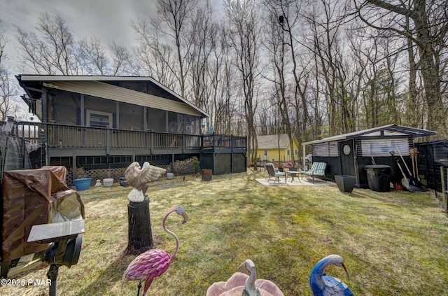 view of yard with a patio area, a wooden deck, and a sunroom