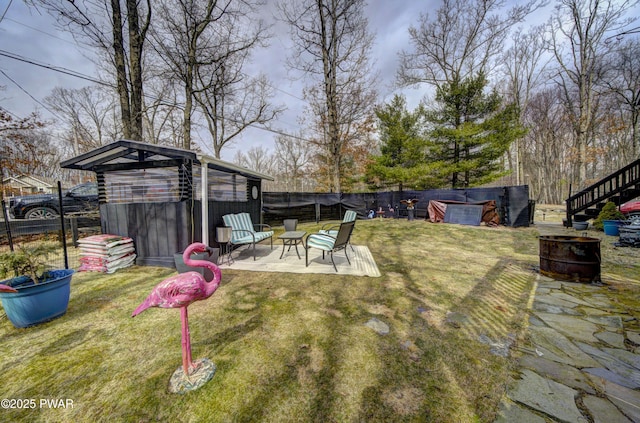 view of yard with a fenced backyard, a patio, a fire pit, and stairway