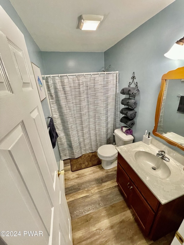 full bathroom with hardwood / wood-style floors, vanity, toilet, and shower / bathtub combination with curtain