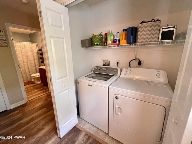 laundry area featuring washing machine and clothes dryer and hardwood / wood-style flooring