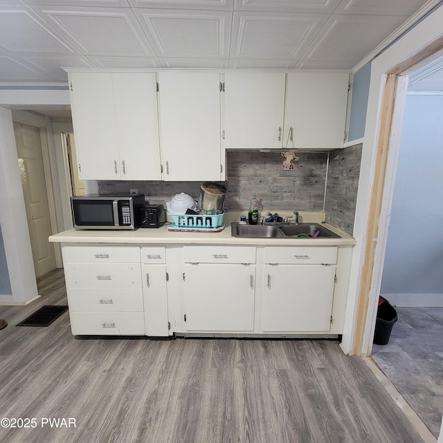 kitchen featuring sink, light hardwood / wood-style floors, and white cabinets