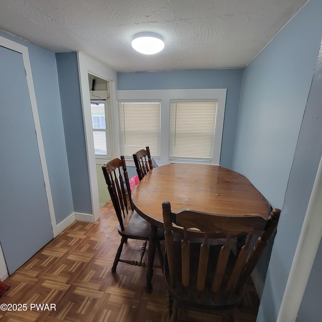 dining area with dark parquet floors and a textured ceiling