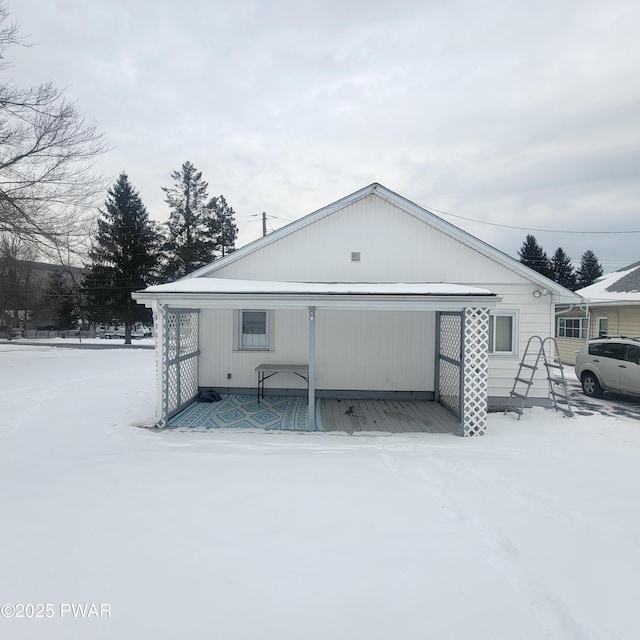 view of snow covered back of property