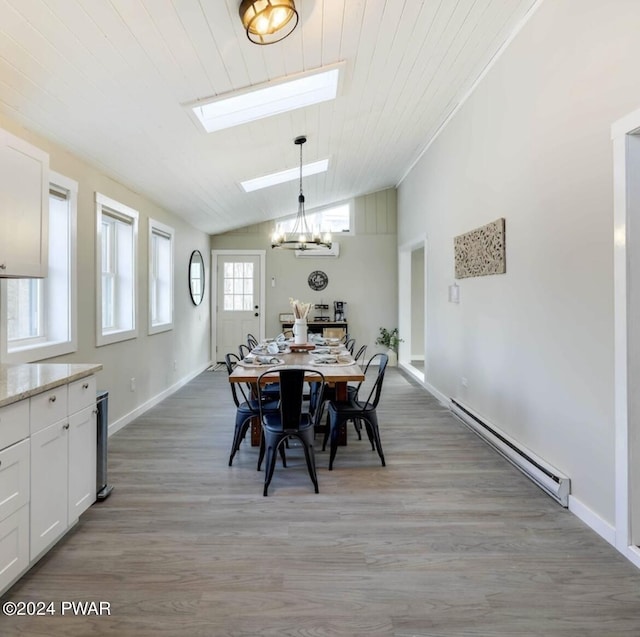 dining space featuring light wood-type flooring, wooden ceiling, a baseboard heating unit, and vaulted ceiling with skylight