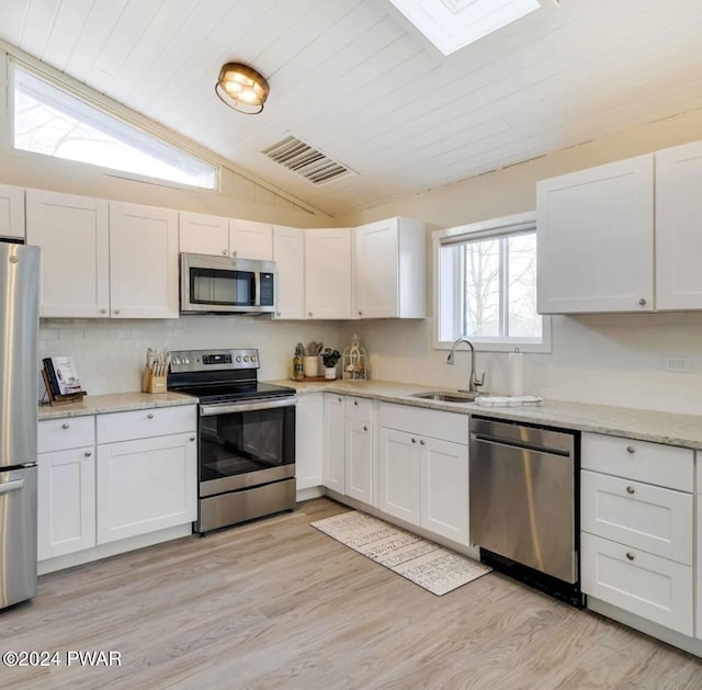 kitchen with white cabinetry, sink, stainless steel appliances, light hardwood / wood-style flooring, and lofted ceiling