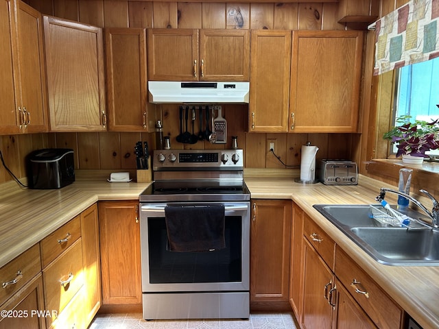 201 Oak Hill Rd, Hawley, PA 18428 - kitchen with under cabinet range hood, stainless steel electric range oven, a sink, and brown cabinets
