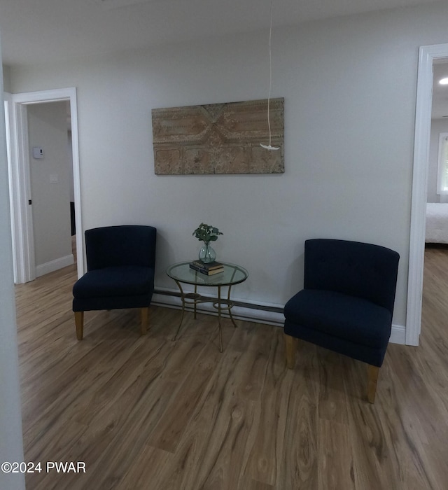 sitting room featuring hardwood / wood-style floors and a baseboard radiator