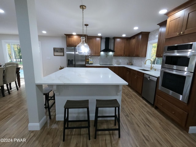 kitchen featuring backsplash, stainless steel appliances, dark wood-type flooring, sink, and wall chimney range hood