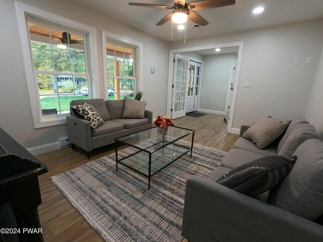 living room featuring ceiling fan, a baseboard radiator, and hardwood / wood-style flooring