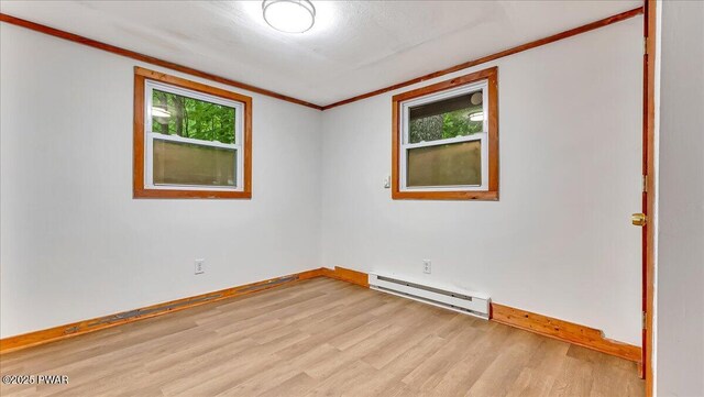 122 Westfall Dr, Dingmans Ferry, PA 18328 - spare room with a baseboard heating unit, baseboards, light wood finished floors, and crown molding