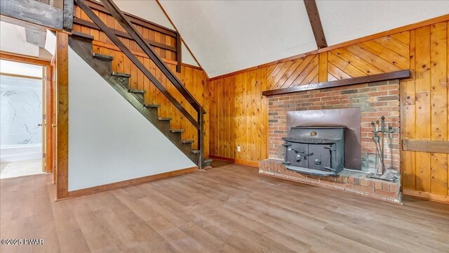 122 Westfall Dr, Dingmans Ferry, PA 18328 - unfurnished living room featuring baseboards, a wood stove, wooden walls, wood finished floors, and stairway