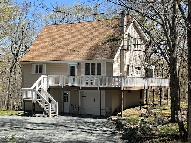 129 Remuda Dr, Lords Valley, PA 18428 - back of property featuring a porch, a garage, aphalt driveway, a shingled roof, and stairs