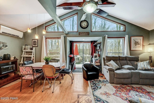 living room with lofted ceiling with beams, plenty of natural light, a wall mounted AC, and light hardwood / wood-style flooring