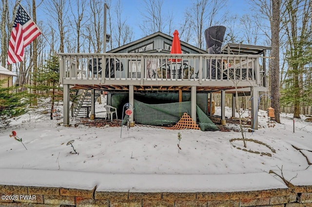 snow covered rear of property featuring a wooden deck