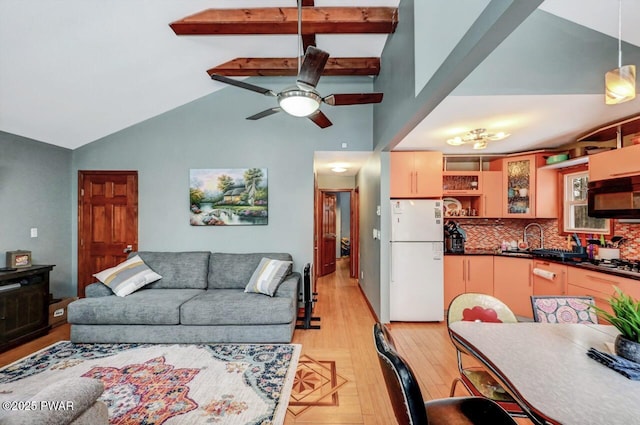 living room featuring sink, light hardwood / wood-style flooring, high vaulted ceiling, and ceiling fan