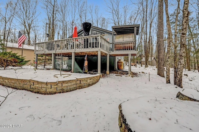 snow covered property featuring a wooden deck and a sunroom