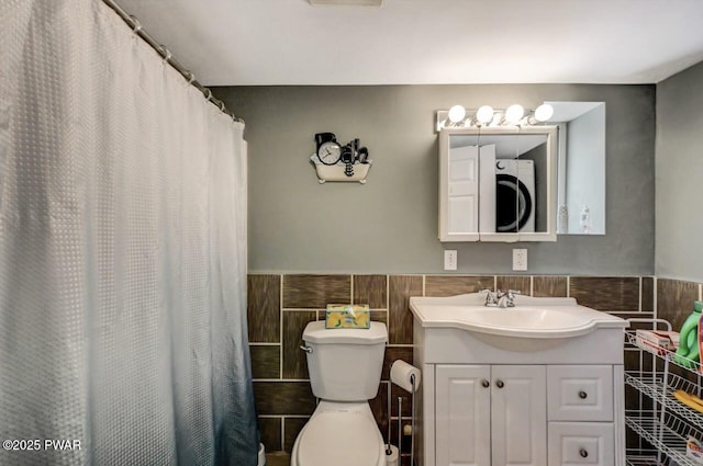 bathroom with vanity, tile walls, and toilet