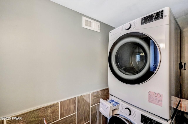 washroom featuring stacked washer and clothes dryer