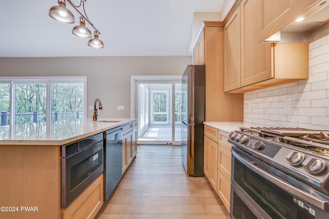 kitchen featuring backsplash, stainless steel appliances, sink, pendant lighting, and light brown cabinets